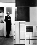Piet Mondrian con una de sus obras