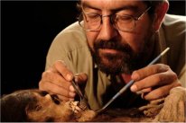 El arqueólogo peruano Guillermo Cock estudiando una de las momias.