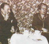 Gabriela Mistral, sentada junto a Pablo Neruda